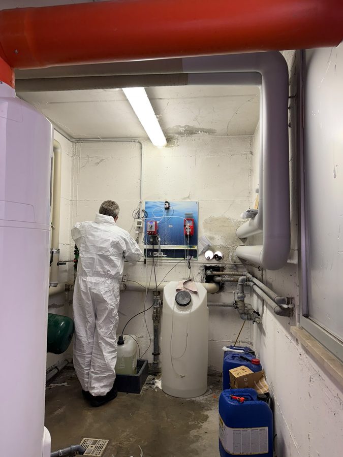 Tecnico EoS in tuta protettiva durante la sanificazione di un impianto idrico